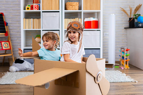 istock Little pilot and passenger play joyfully in a cardboard airplane, symbolizing creativity and friendship 2243931354