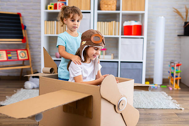 istock Little pilot and passenger play joyfully in a cardboard airplane, symbolizing creativity and friendship 2243931364