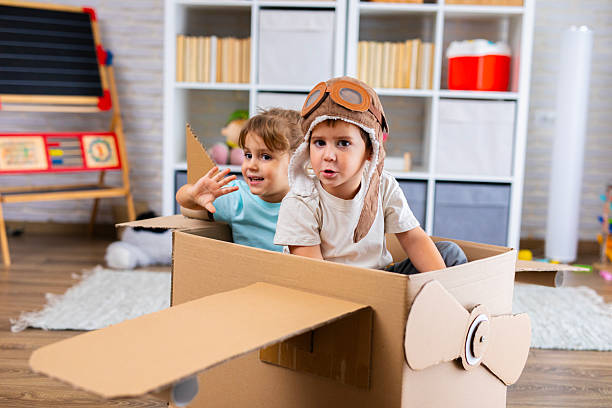 istock Little Pilot and Passenger Playing Together in a Cardboard Airplane 2243931480