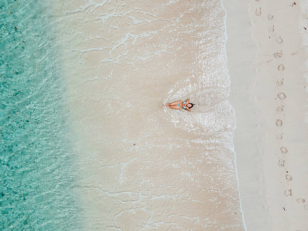 istock Woman Relaxing on Shoreline with Clear Water 2243933023