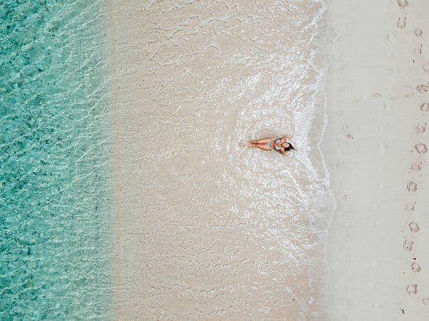 istock Woman Relaxing on Shoreline with Clear Water 2243933027