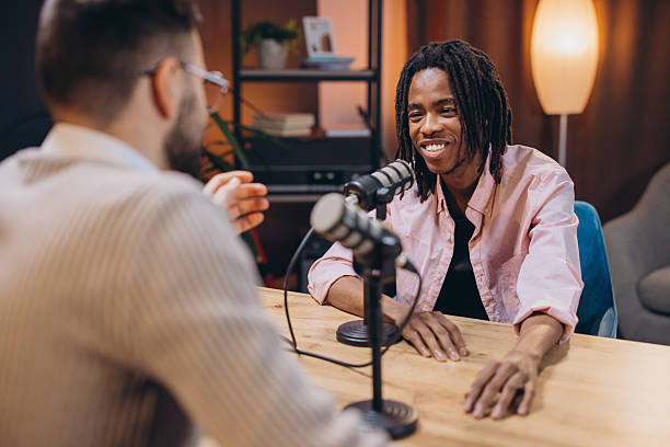 istock Professional podcast recording with young male hosts discussing content, sharing microphone space in well equipped studio setting 2243934776