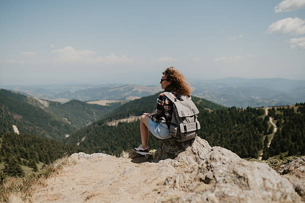 istock Hiker With Backpack Resting on Rocky Outcrop Overlooking Scenic Mountain Valley Panorama During a Clear Day 2243934887
