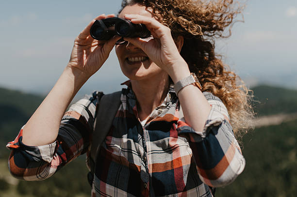 istock Woman With Binoculars Exploring Mountain Landscape 2243934907