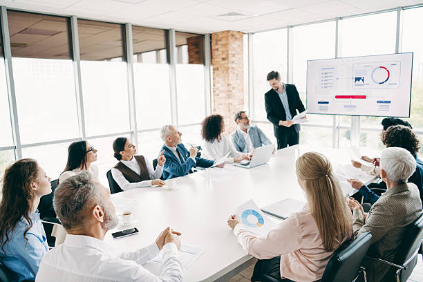 istock Diverse team gathers around a conference table in a modern office, collaborating over charts and presentations for a business project. 2243935402