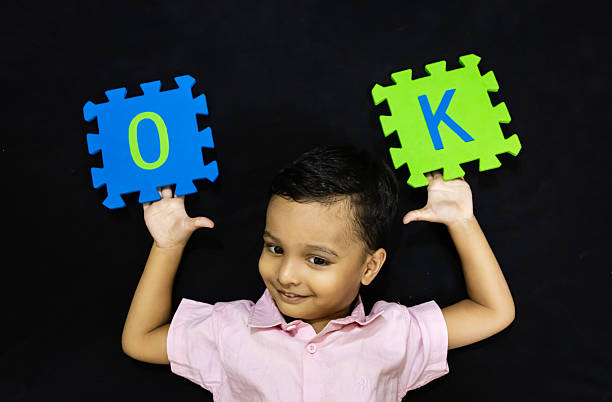 istock toddler expressing agreement or positivity with ok letter mats 2243935434
