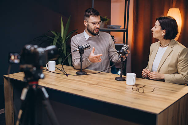 istock Content creators recording a podcast episode using professional microphones and a camera in a modern studio 2243935471