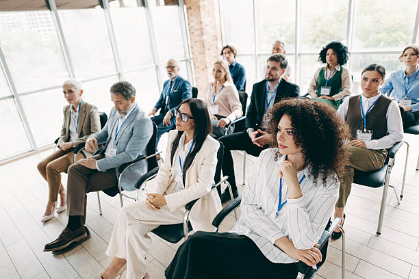 A modern office hosts a group of professional individuals participating in a formal conference, concentrating on teamwork and strategy development.