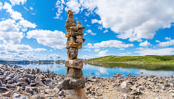 Vardar stone cairns by Orteren lake in summer Norway scenic travel with mountains and nature