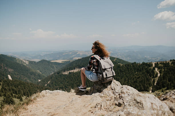 istock Hiker With Backpack Resting on Rocky Outcrop Overlooking Scenic Mountain Valley Panorama During a Clear Day 2243936025