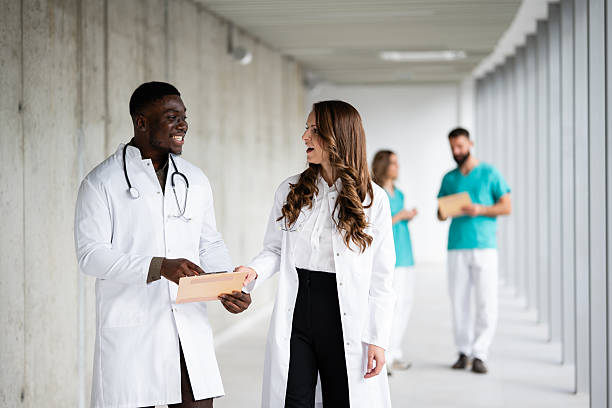 istock Doctors discussing medical reports in hospital hallway 2243936579