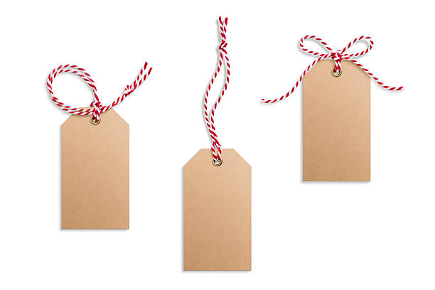 istock Three blank paper gift tags, hang tags, price tags or cloth labels with red and white twisted string isolated on a white background. 2243937900