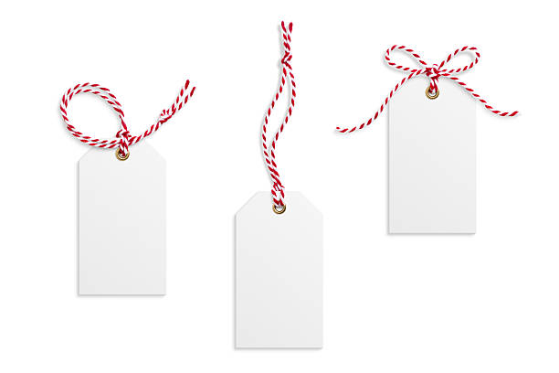 Three blank paper gift tags, hang tags, price tags or cloth labels with red and white twisted string isolated on a white background. High resolution. Christmas or holiday label