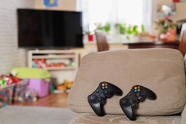istock Game controllers on sofa in living room 2243938608