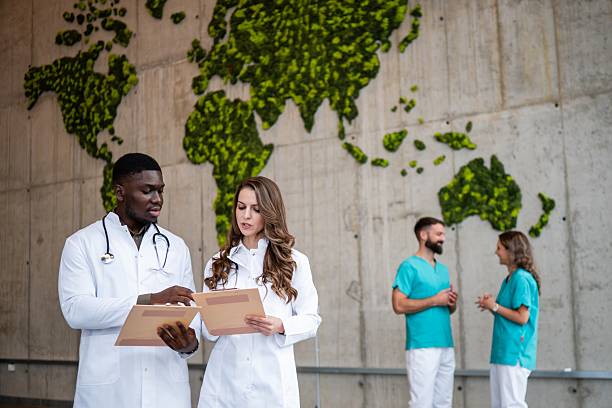 istock Diverse doctors discussing medical files with world map background 2243940360