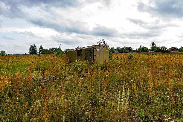 istock An abandoned trailer in a rural field under a cloudy sky 2243940523