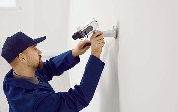 istock Professional male technician repairs or installing cctv camera system on wall inside house. 2243941582