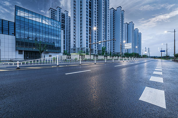 Clear urban asphalt street running through a modern neighborhood with high rise apartment buildings.