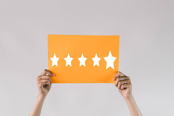 istock Five Star Rating: Hands Holding Orange Card for Excellent Customer Satisfaction Review 2243943246