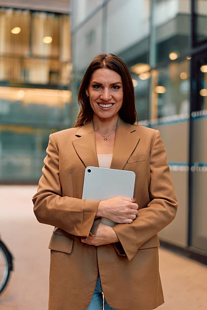 istock Confident businesswoman smiling and holding a tablet in office setting 2243945846