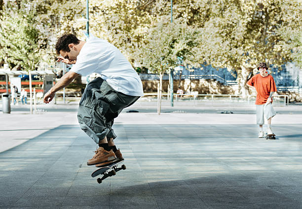 Young skater jumps mid-air while performing a trick on the street