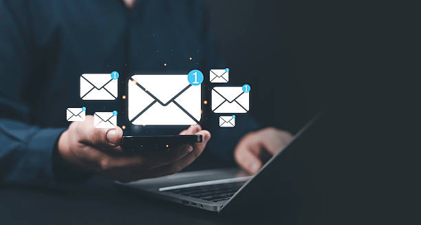 istock Businessman holding smartphone with floating email icons and notifications, symbolizing digital communication, online messaging, email marketing, data exchange, and modern technology. 2243947730