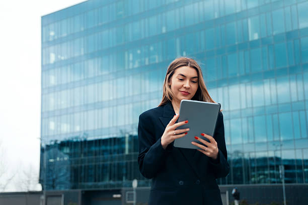 istock Business Professional Engaging With Tablet in Front of Modern Office Building During Cloudy Day 2243949223