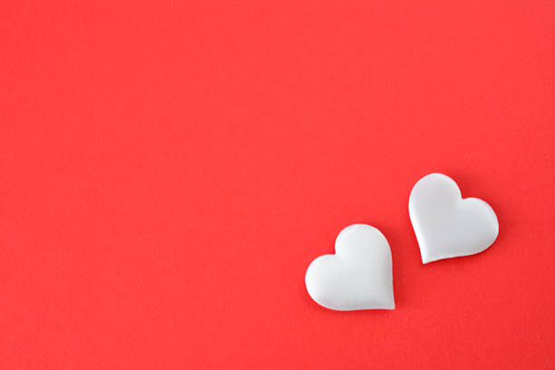 Two White Hearts on a Vibrant Red Background blank space