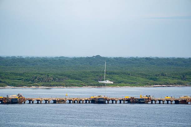 Costa Maya, Mexico – October 16, 2025: A yacht stranded on a tropical shoreline near a wooden pier
