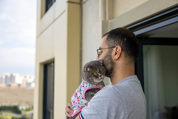 istock Man Spending Leisure Time with Cat on Balcony 2243949910