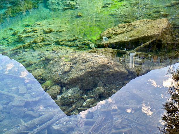 A mountain peak reflected in the crystal clear glacier water of Grassy Lake near Canmore, Alberta.