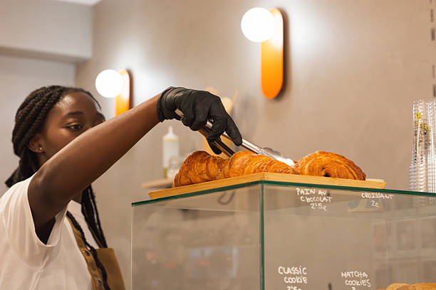 istock Woman serving fresh croissants at bakery display case 2243956683