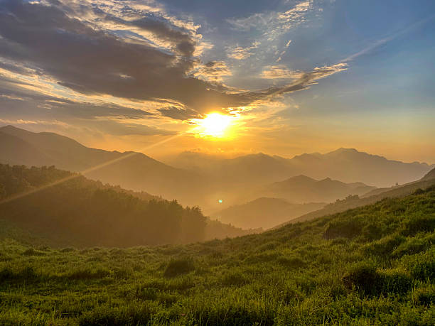 istock Sunrise over mountainous landscape with green grass and clouds 2243956763