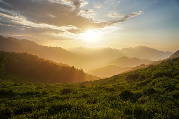 istock Sunset over lush green mountainous landscape with rolling hills 2243956785