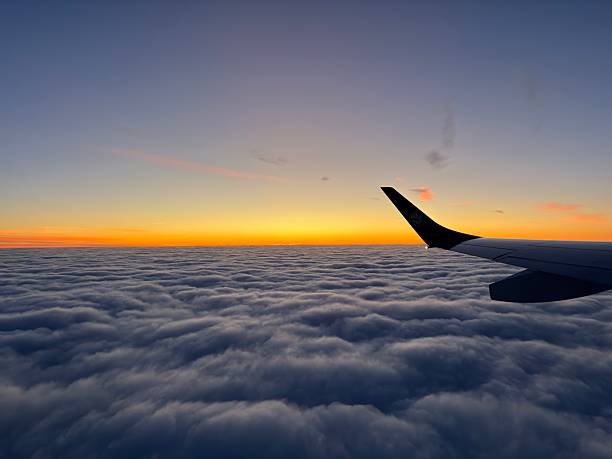 istock Sunrise over a layer of clouds from a plane window 2243958039