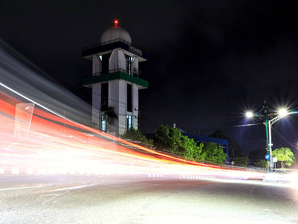 Balikpapan-Indonesia january 19, 2025 : Illuminated BMKG tower and official building at night, with red light streaks from passing vehicles in the foreground using a long exposure technique at balikpapan city, east Borneo.