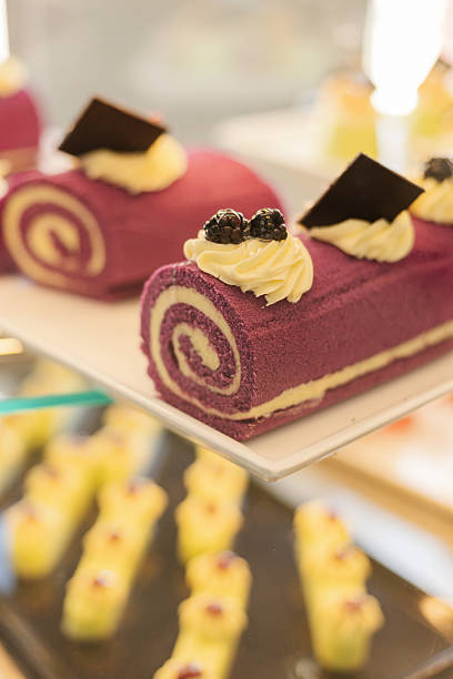 istock Beautifully decorated purple roll cakes topped with cream and chocolate sit invitingly on a dessert display, attracting attention at a festive gathering 2243961722