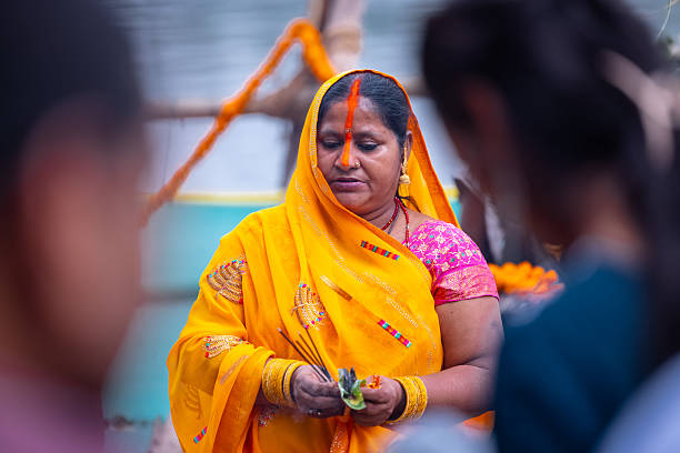 Ghaziabad, Uttar Pradesh, India - October 2025: Chhath Puja, Portrait of unidentified hindu female devotee performing rituals of chhath with standing in river to worship lord sun during sunset.