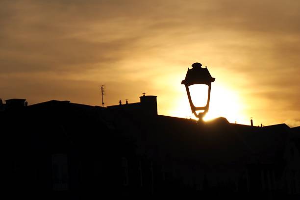 Sunset Silhouette with Lamppost and City Skyline