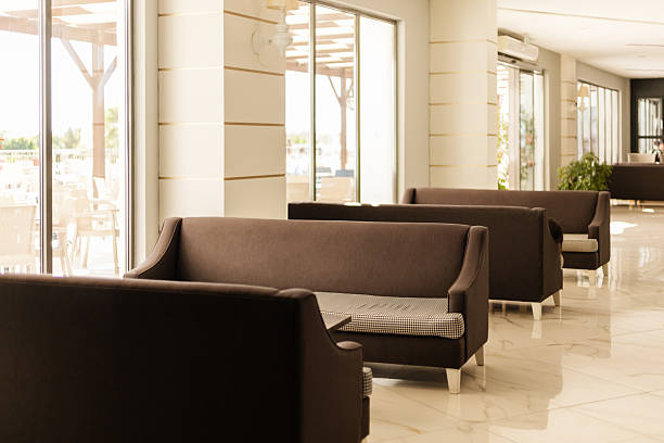 istock The seating area features stylish brown sofas arranged in a bright, spacious cafe. Large windows allow plenty of natural light to fill the room, creating an inviting atmosphere 2243962124