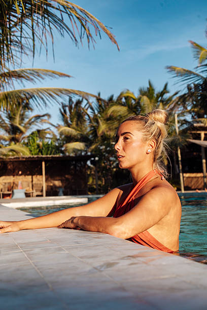 istock Relaxed woman enjoying sunset by tropical pool 2243964824