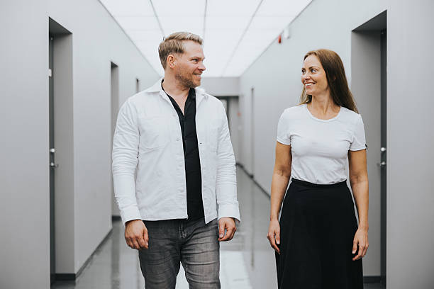 istock Business colleagues walking through office hallway engaging in casual conversation 2243964882