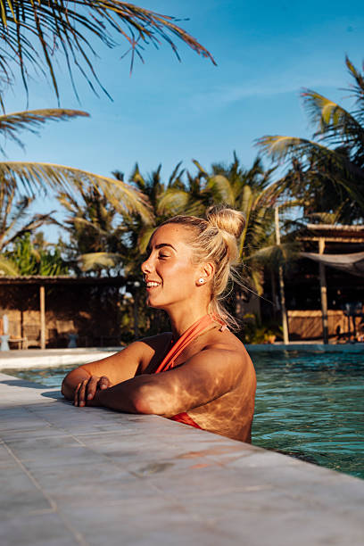 istock Relaxed woman enjoying sunset by tropical pool 2243965659