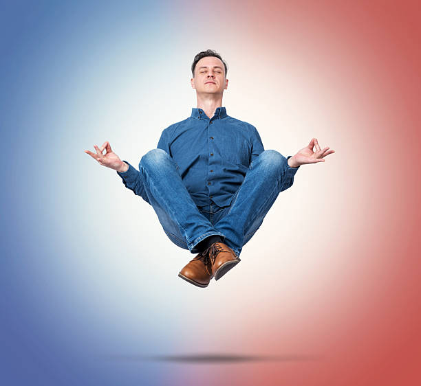 istock Calm man levitating in lotus pose, meditating between blue and red gradient light symbolizing balance of opposite forces, mindfulness, harmony and inner peace concept. 2243966184