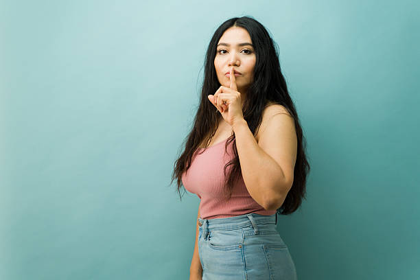 istock Serious woman asking for silence, keeping a secret 2243968190