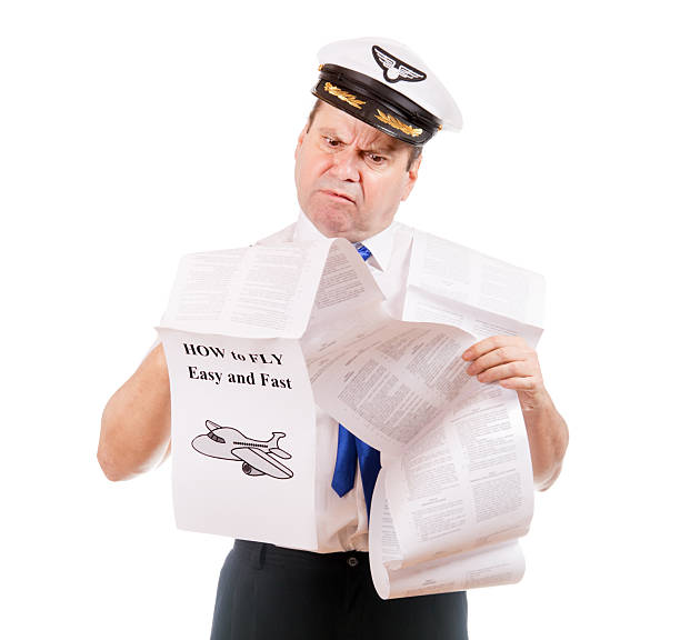 The pilot looks into instructions about using the aircraft, isolated on white background. Aircraft captain is studying a manual about flying.