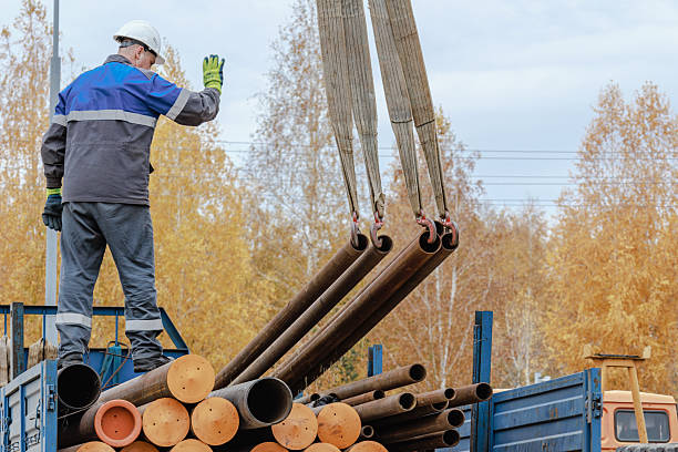 istock Construction Worker Directing Crane with Steel Pipes 2243970869