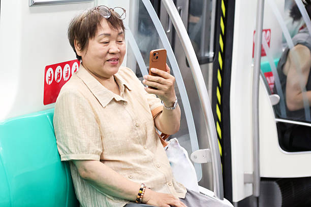 istock An elderly woman uses her smartphone while commuting on the subway. 2243971125
