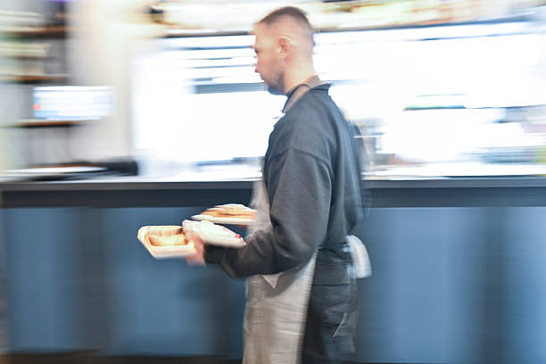 istock Busy Chef In Apron Carrying Plates Through Blurred Kitchen At Breakfast Bar Early Morning 2243974528