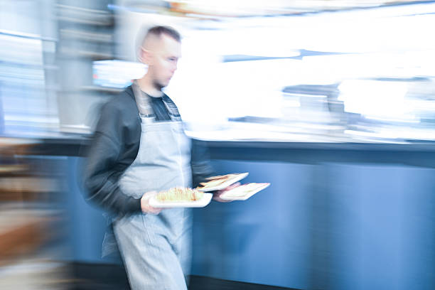 istock Busy Chef In Apron Carrying Plates Through Blurred Kitchen At Breakfast Bar Early Morning 2243974579